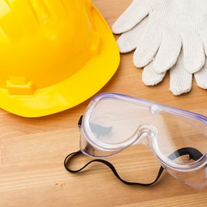Construction hat, goggles and gloves on a workbench
